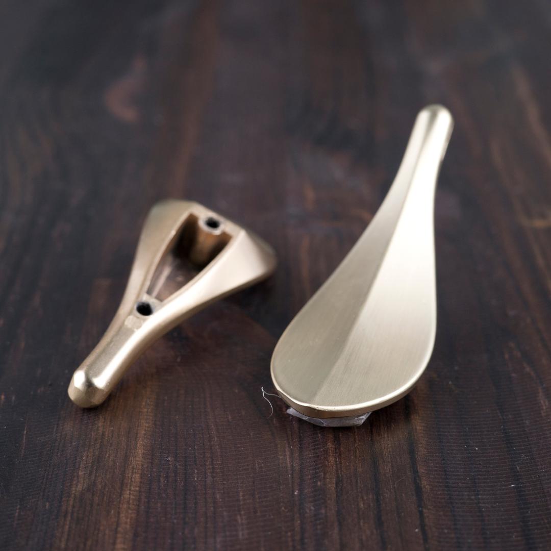 Lehden mallinen metallivedin esim. laatikkoon, kaappiin tms.   Kiinnitysruuvit 2 kpl sisältyvät tuotteeseen. Voidaan kiinnittää yhdellä tai kahdella ruuvilla. Ruuviväli 33 mm.  Myydään yksittäin.  Väri: kulta  Koko: 90x30 mm.